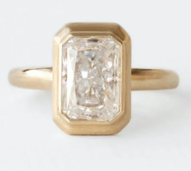 An emerald rose cut light grey opaque diamond set in a hand engraved milgrain bezel on a 18k yellow gold band.