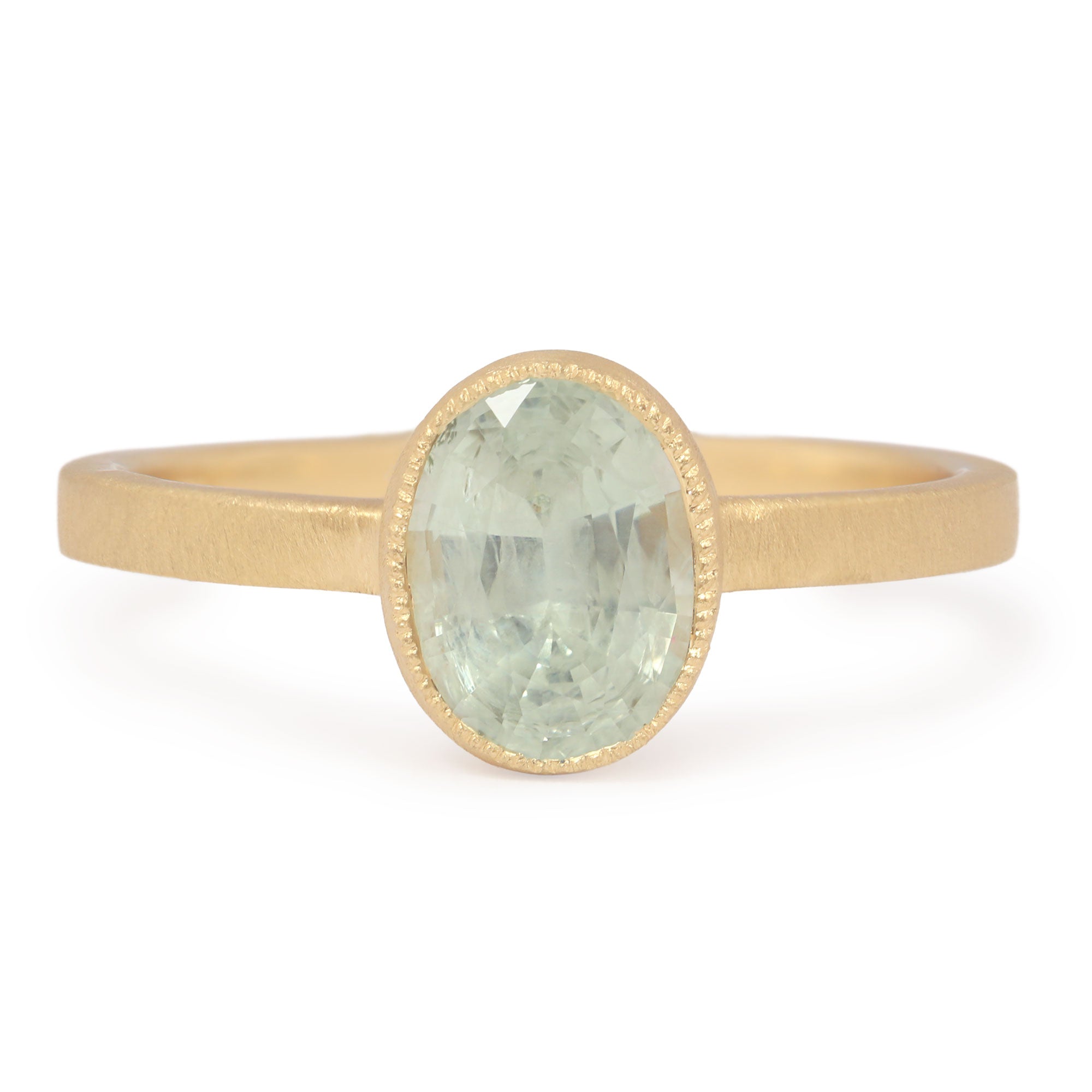 Gold ring with a green Montana sapphire gemstone on a white background