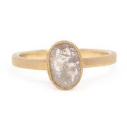 Gold ring with a large, oval-shaped stone on a white background