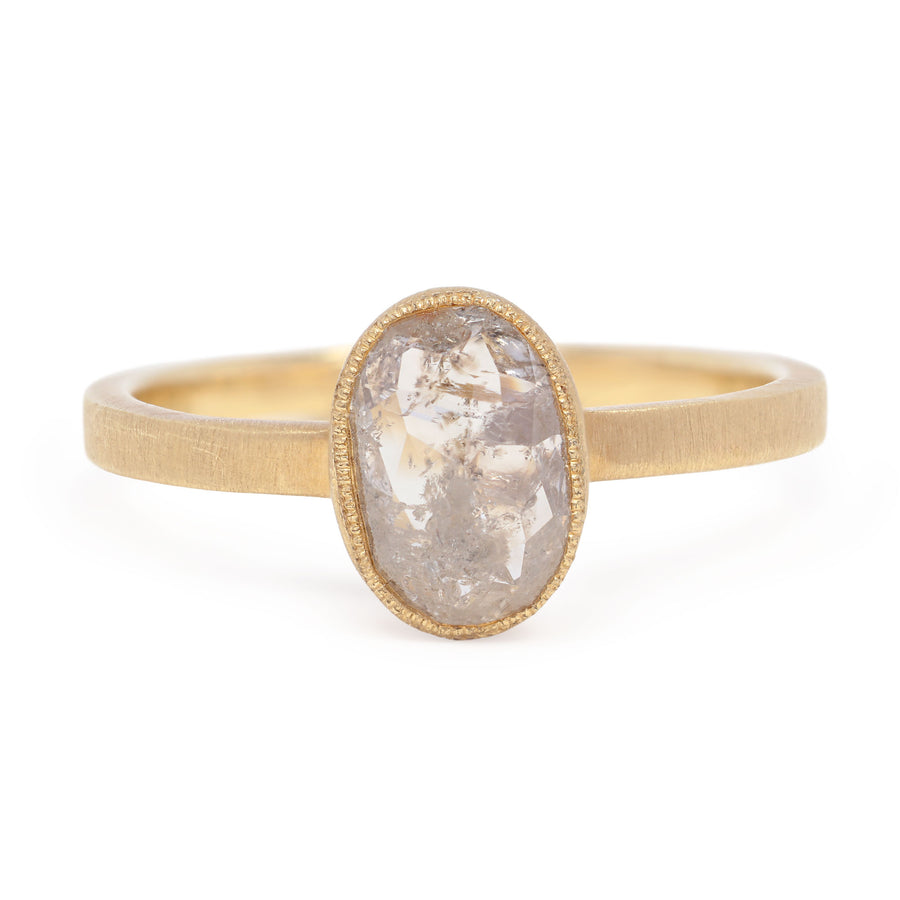 Gold ring with a large, oval-shaped stone on a white background