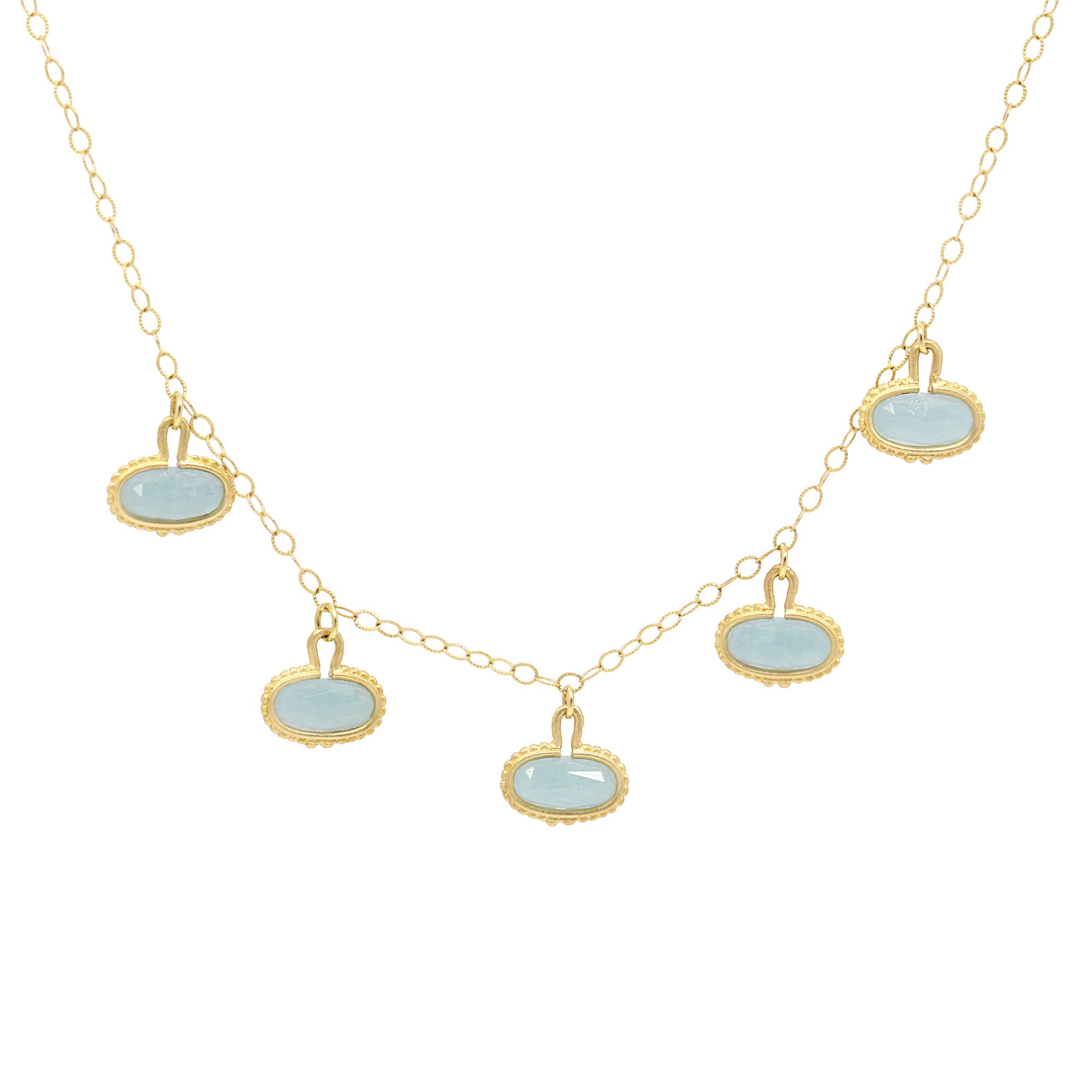 Necklace with gold chain and light blue pendant drops on a white background