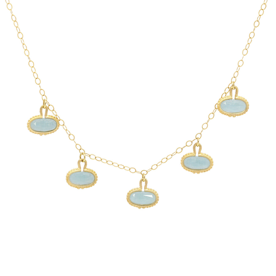 Necklace with gold chain and light blue pendant drops on a white background