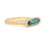 Gold ring with a blue gemstone on a white background