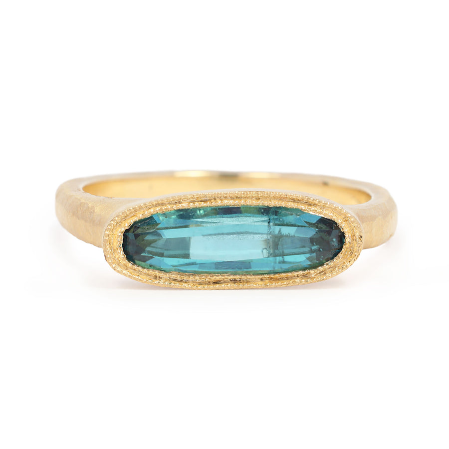 Gold ring with a blue gemstone on a white background