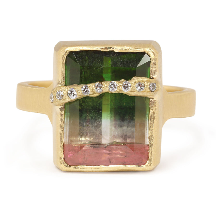 Gold ring with a green and pink gemstone and diamond accents on a white background