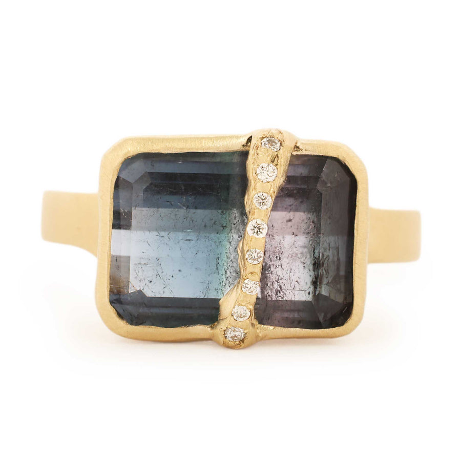 Gold ring with a large square gemstone and smaller stones on a white background