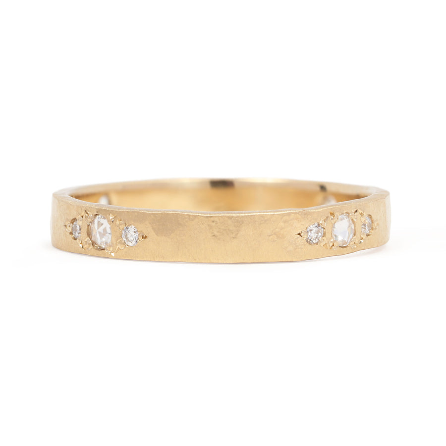 Gold ring with embedded diamonds on a white background
