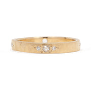 Gold ring with embedded diamonds on a white background