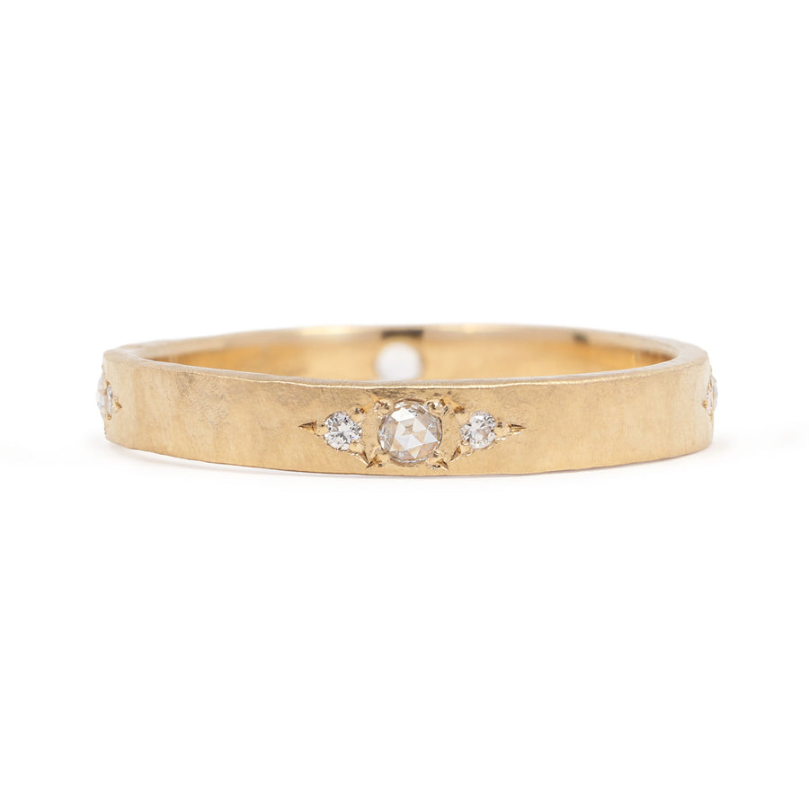 Gold ring with embedded diamonds on a white background