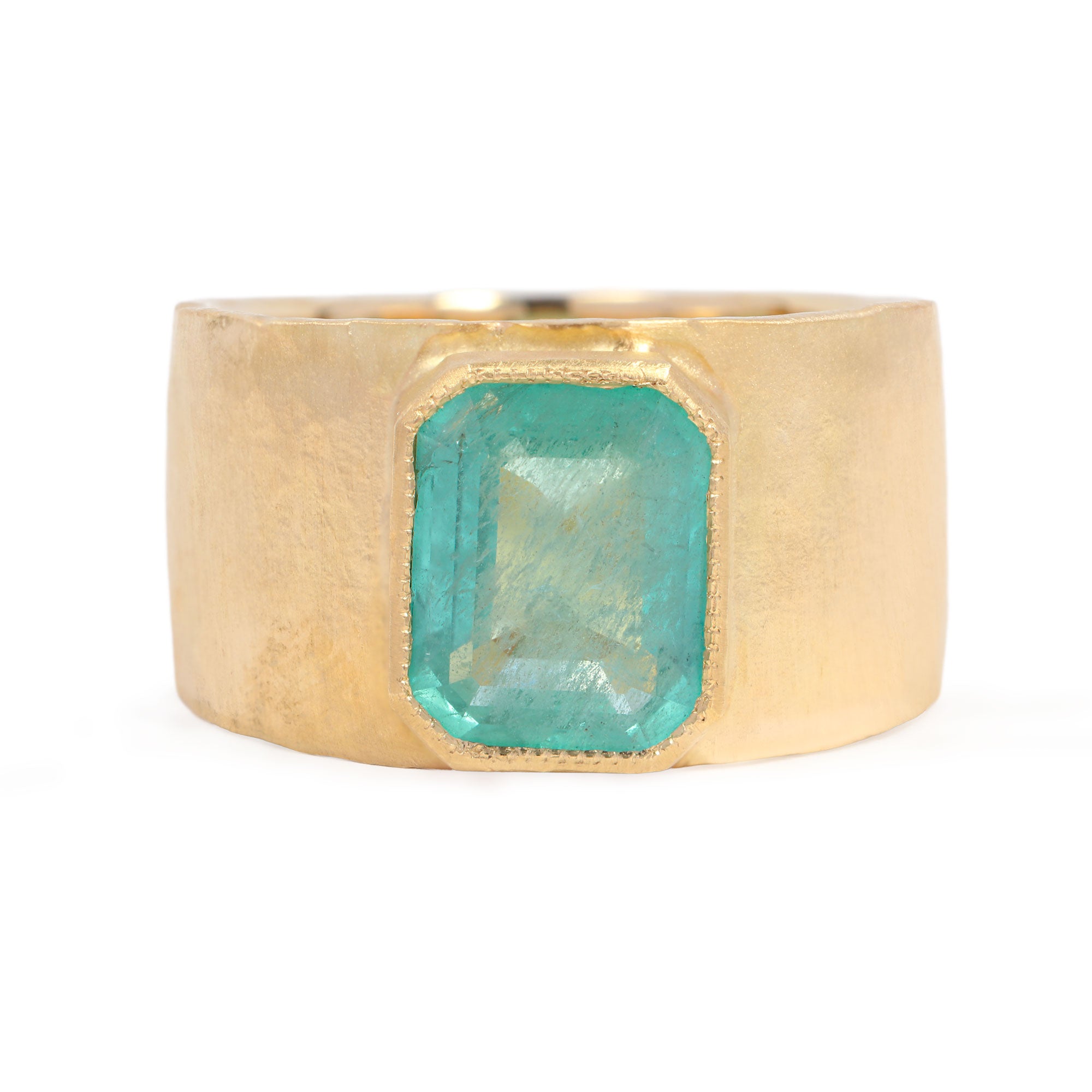 Gold ring with a green gemstone on a white background