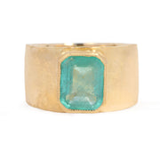 Gold ring with a green gemstone on a white background