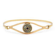 Gold bracelet with an eye design on a white background