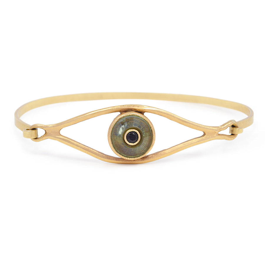 Gold bracelet with an eye design on a white background