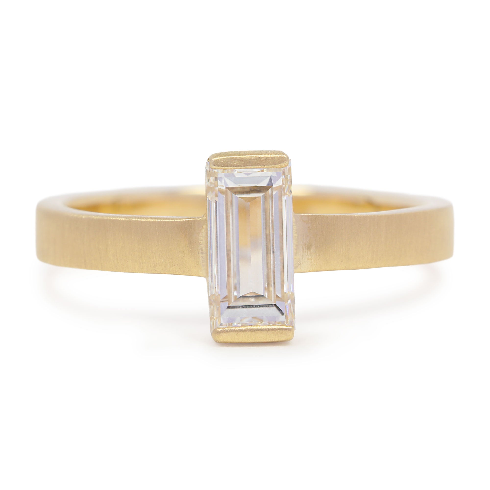 Gold ring with a rectangular diamond on a white background