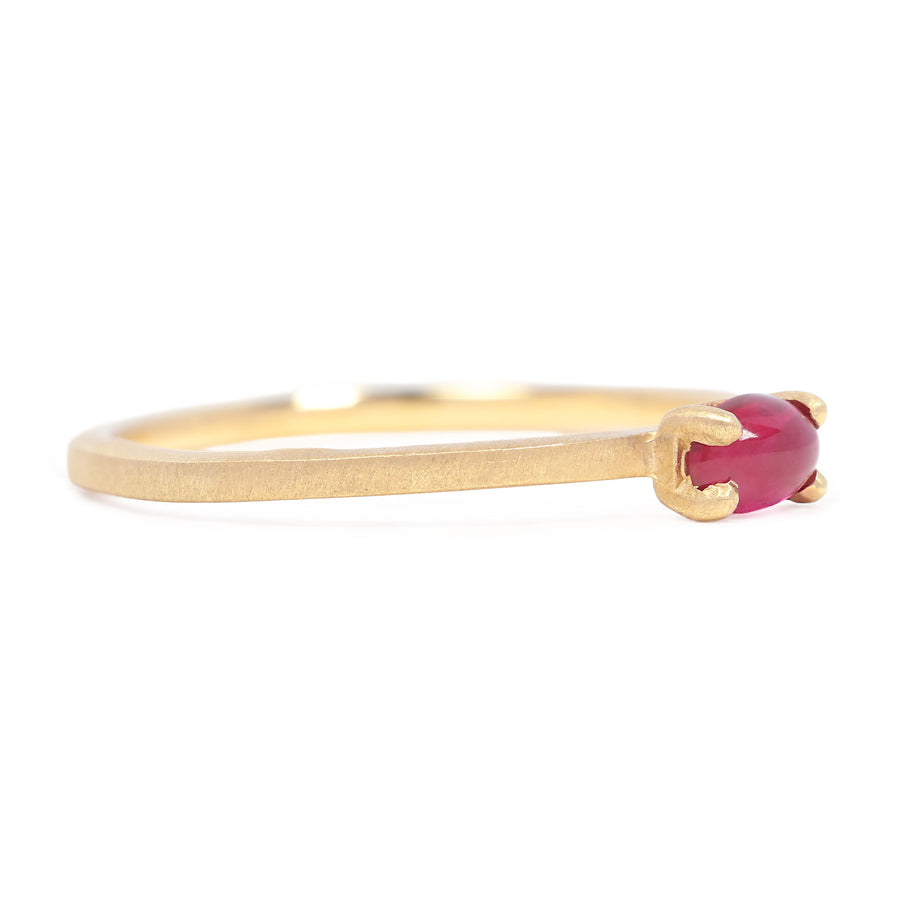 Gold ring with a red gemstone on a white background